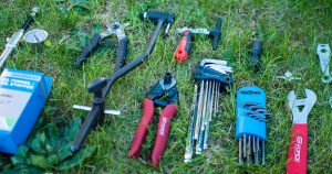 Best Bike Tool Kits and Tools: Various bike tools (wrenches, chain breaker, etc.) in a grass