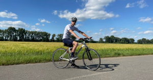 Best Hybrid Bikes Under 500: Me standing over a cheap hybrid bike on a bike path