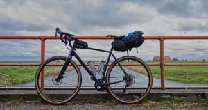 How to Choose a Gravel Bike? A gravel bike lean against bridge railings