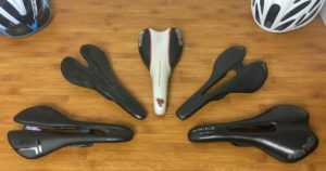 How to Choose a Bike Saddle: Multiple bicycle saddles on a wooden desk