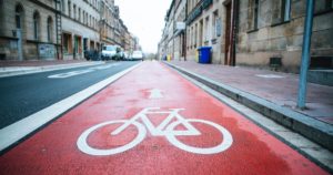 Disadvantages of Cycling: Red cycling lane next to car lane