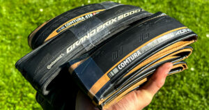 What are tubeless tires and are they worth it?: Me showing a few tubeless road tires (Tufo Comtura 4 TR, Continental Grand Prix GP5000 S TR, Tufo Comtura Prima).