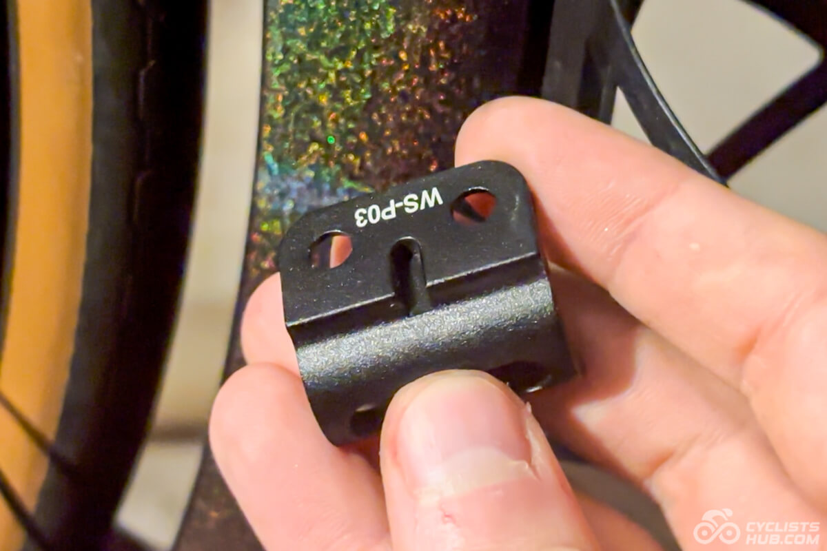 Me holding the Winspace T1600 front derailleur hanger showing its groove for the Di2 wire.