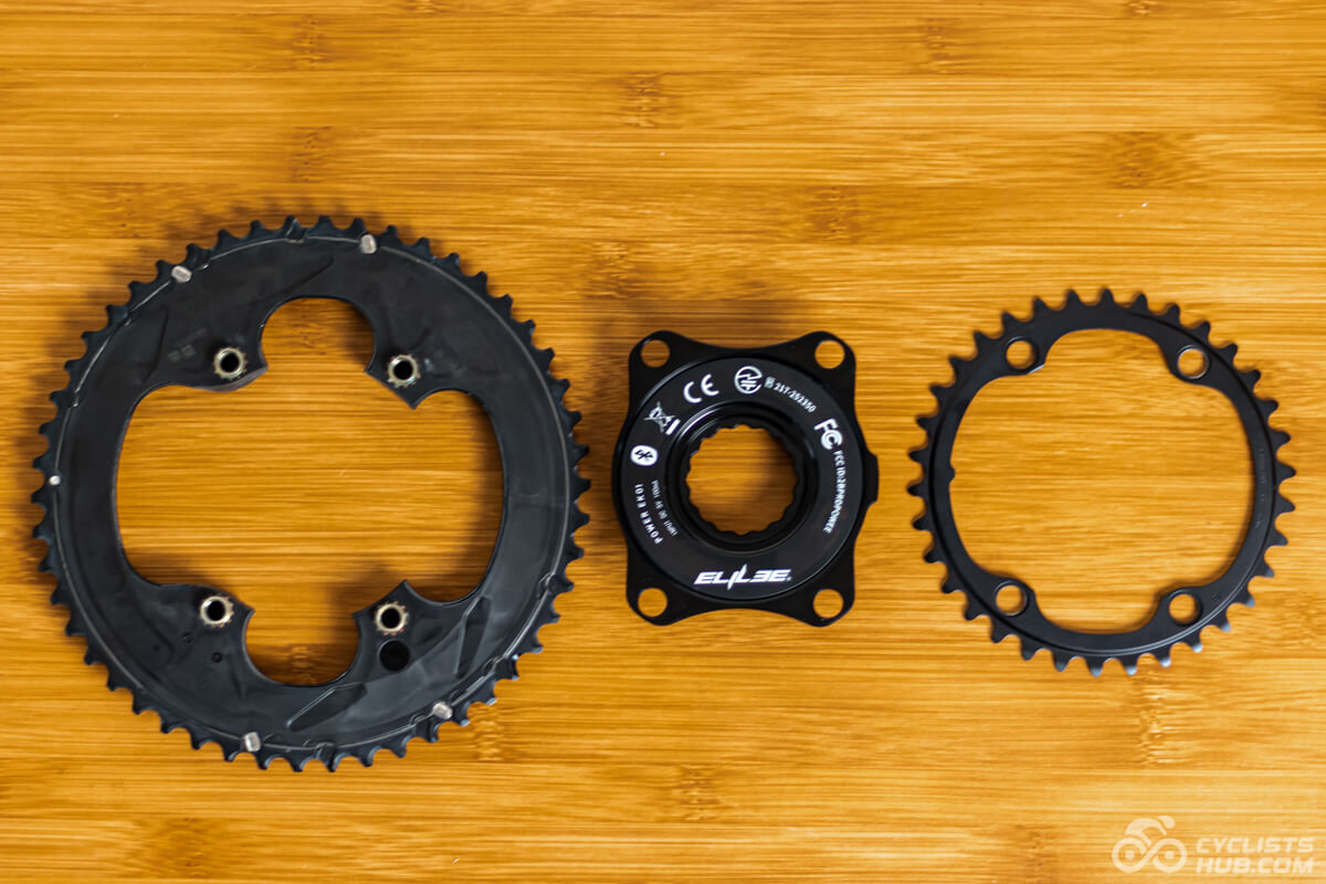 Shimano Ultegra chainrings and Elilee EK01 power meter on a wooden table.