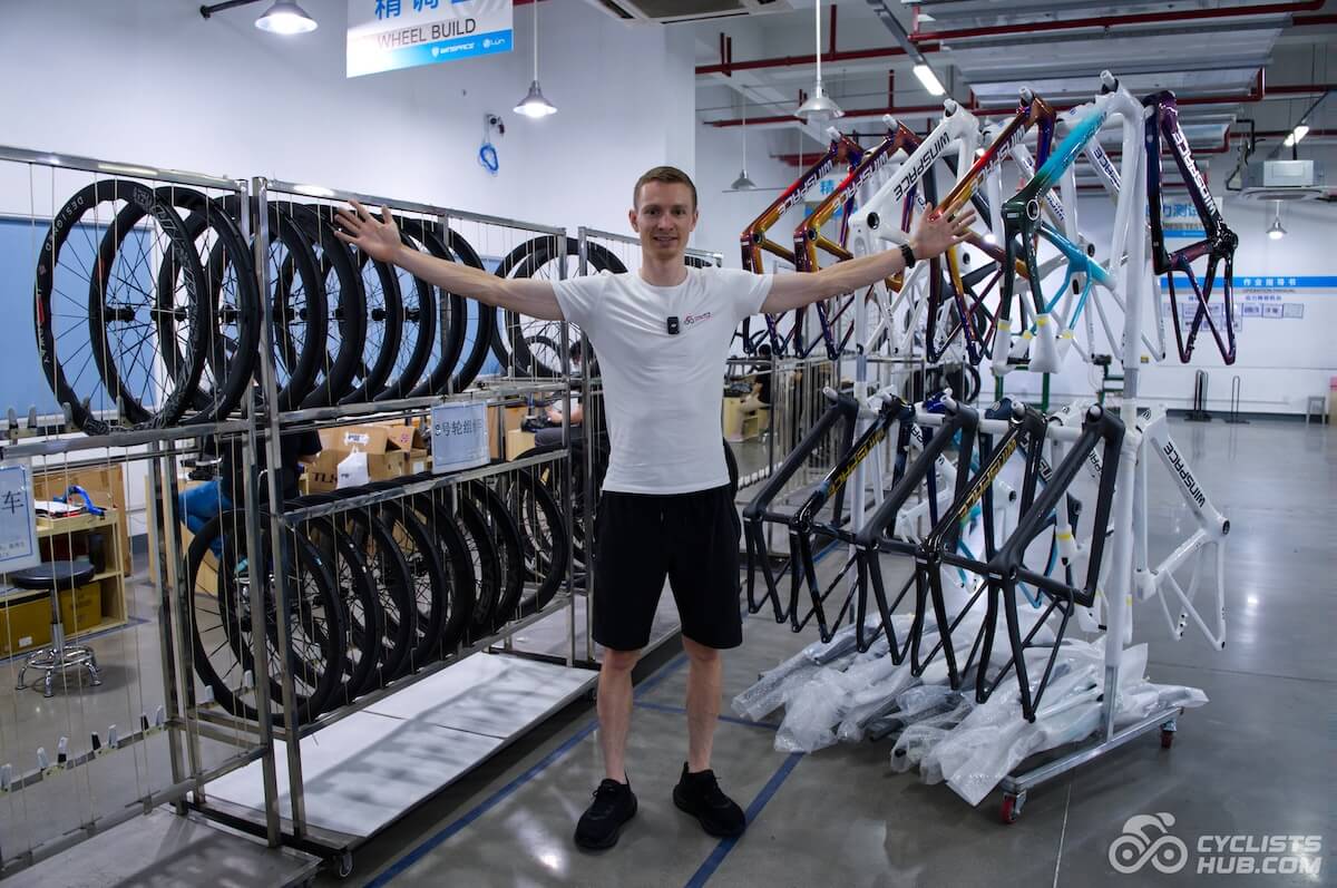 Petr Minařík standing in the Winspace assembly line with Lún wheels and Winspace frames behind him.