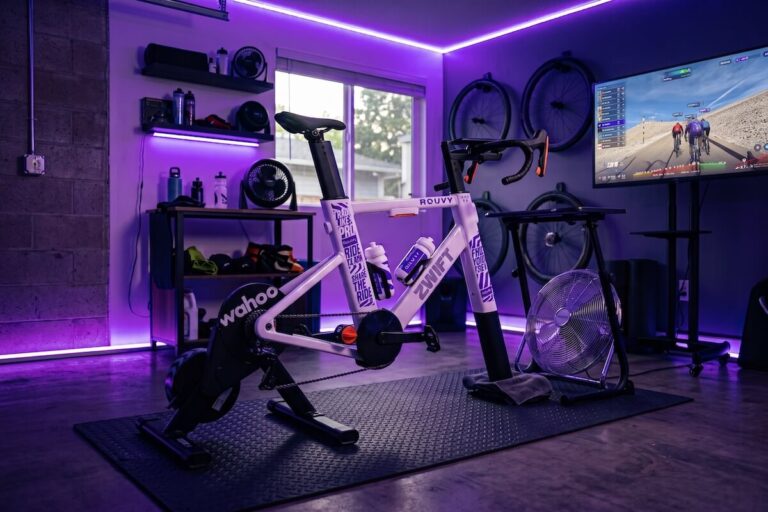 Zwift Ride (ROUVY edition) in a pain cave with violet neon lights.